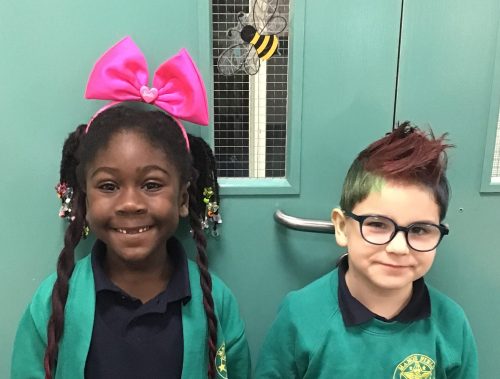 Two children with Mad Hair Day hairstyles smiling at the camera